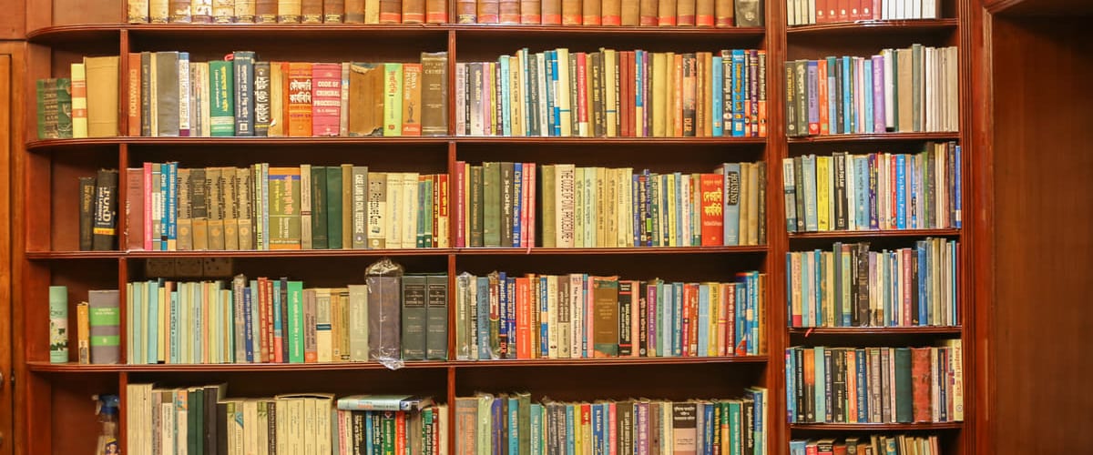 A wide view along one wall of the chambers’ library: bound law reports across the upper shelves, statutes and reference works below.