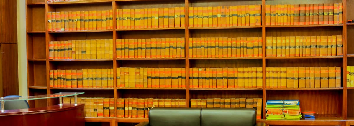 The chambers’ full run of bound law reports, shelf upon shelf across the width of the wall.
